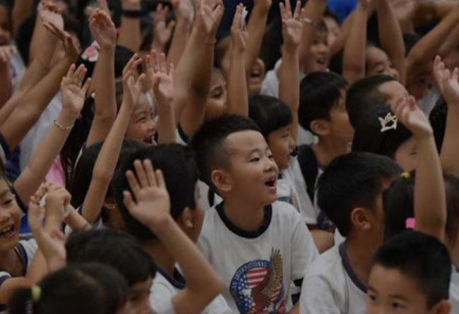 Kids smiling and raising hands